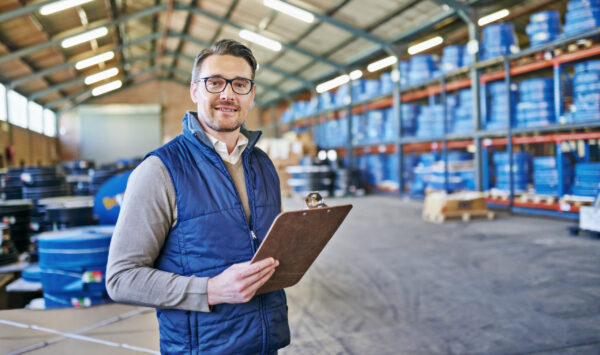 Shot of a young man holding a clipboard in a warehouse.